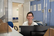 © Raul Navarro/Stocksy - Friendly receptionist at health clinic desk