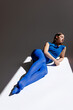 © Tania Cervian/Stocksy - Dreamy slender woman in bodysuit lying on floor