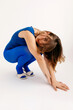 © Tania Cervian/Stocksy - Dreamy brunette woman squatting sideways and looking at camera