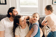 © Lea Jones/Stocksy - family with young children hangin out on the sofa