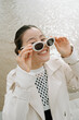 © Azamat Mukanov/Stocksy - Asian woman in sunglasses by the boardwalk.