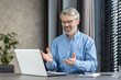 © Liubomir - A senior man is happily engaging in a video call in his home office, using technology for work