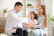 © Pixel-Shot - Little girl with her mother and doctor using inhaler at home