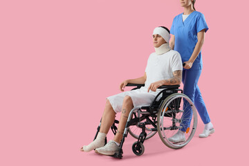 Poster - Injured young man in wheelchair after accident with doctor on pink background