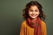 © MediaRaw - A young girl wearing a red scarf and a yellow shirt is smiling
