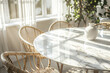 © youriy - Bright dining area with a marble table and wicker chairs bathed in sunlight from large windows and a vase