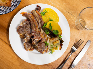 Canvas Print - Delicious fried lamb ribs with potatoes and peppers served on plate