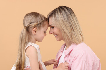 Canvas Print - Family portrait of happy mother and daughter on beige background