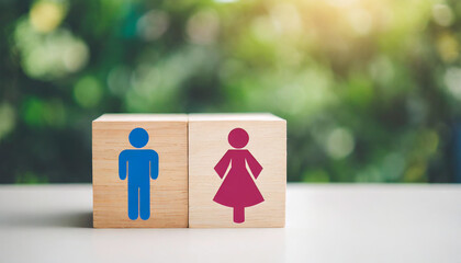 Wooden blocks with male and female gender signs on a white table, symbolizing gender identity and equality, against a clean, empty background