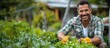 © Алина Бузунова - happy caucasian man holding shears and pruners, standing in the garden with green trees and bushes at sunny summer day.