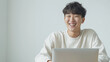 © Ad Copy Space Photo - 笑顔でデスクワークをこなす若い男性 - 在宅ワークとオフィスでの作業シーン_白バック