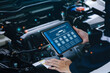 © Deemerwha studio - car service and checking concept. Hand of a mechanic holding the tablet for maintenance checklist vehicle, Software for manager check to repair, technology checkup automotive. Customer service concept