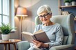 © Юлия Клюева - An elderly retired woman, a modern grandmother with glasses, is reading a book in the interior of the living room, sitting in an armchair at home in natural light.