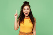 © ViDi Studio - Young fun smart proactive woman of African American ethnicity wear yellow tank shirt top holding index finger up with great new idea isolated on plain pastel light green background. Lifestyle concept.