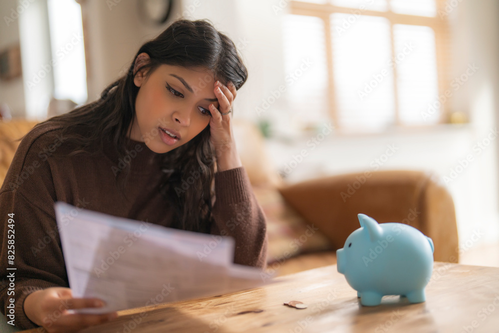 Worried young indian woman reading letter savings employment tax paying energy bill confused upset