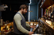© Nomad_Soul - Bartender using digital panel to for processing bar visitors orders