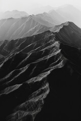 Minimalist aerial view of mountain ridges, showcasing sharp lines and natural patterns in the terrain. 