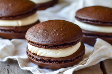 Wall Mural - there are three chocolate macarons with cream filling on a napkin