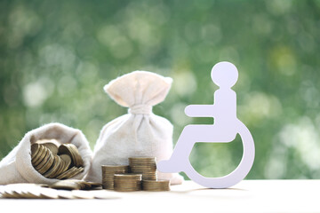 Wall Mural - Man on wheelchair and coin money on natural green background,Save money for prepare in future and handicapped person concept