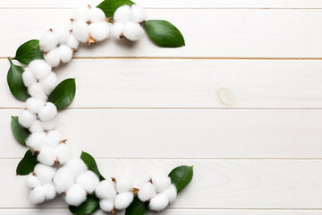 Wall Mural - Autumn Floral Flat lay background composition. Dried white fluffy cotton flower branchwith green leaf top view on colored table with copy space