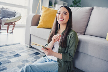 Wall Mural - Photo of pretty young woman sit floor pencil notebook wear shirt modern interior apartment indoors