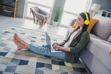 Canvas Print - Full length portrait of nice young girl use netbook headphones wear green shirt modern interior flat indoors