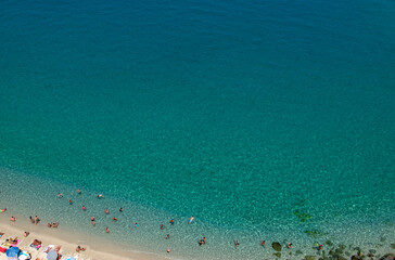 Wall Mural - Aerial view of sandy beach with swimming people in sea with transparent blue water in summer.