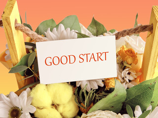 Text GOOD START written in a bouquet of flowers on a white business card