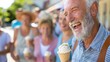 © Jullia - Cheerful Senior Man Enjoying Ice Cream Cone on Sunny Day Outdoors