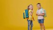 © Felippe Lopes - Happy children with school backpacks, ready for a new school year, standing against a vibrant yellow background.