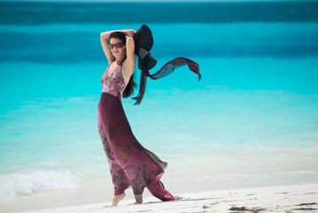 a girl in a dress and hat walks along the white sand, Siren beach in Cuba, Caribbean sea, palm trees on the beach, ocean shore,