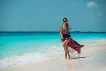 a girl in a dress and hat walks along the white sand, Siren beach in Cuba, Caribbean sea, palm trees on the beach, ocean shore,