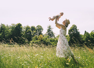 Wall Mural - Mother and baby. Concept of natural maternity and motherhood. Beautiful woman and little baby happy together in green nature background. Loving mom with child outdoors.