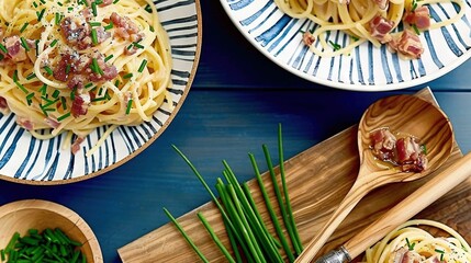   Two plates of pasta with bacon and green beans on a wooden cutting board beside a bowl of green beans