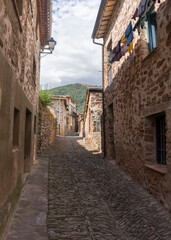 Wall Mural - A narrow alley with a stone wall on each side. The alley is lined with houses and has a cobblestone