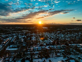 Wall Mural - the sunset is shining over an area with houses and clouds