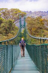 Male tourist crossing one of the eight Suspension bridges in Monteverde cloud forest reserve in Monteverde, Costa Rica