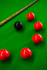 the cues for a snooker game are on the green felt