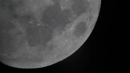 Video of the moon moving in its orbit in a black space taken with an astronomical telescope