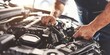 © Denis Tuev - An experienced mechanic fixing a car engine in a clean and bright auto repair shop
