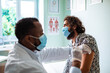 © Marko Geber - Doctor administering a vaccine to a male patient in a medical office
