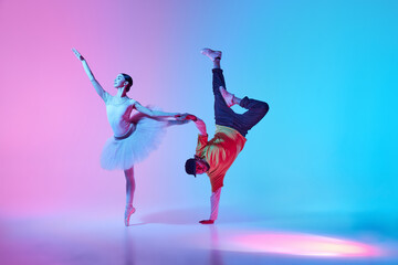 Breaking boundaries between classical and modern art. Young girl, ballerina on pointe dancing with young man performing break dance in neon light. Concept of classical and modern dance, performance