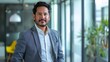 © Bijac - confident latino businessman standing proudly in modern office professional leadership portrait