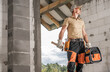 © Tomasz Zajda - Construction Contractor Worker Holding Tool Bag and Chainsaw