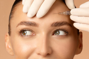 closeup shot of young caucasian woman getting beauty cosmetic injection in forehead, beautiful lady 