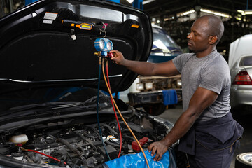 mechanic worker fixing and checking a car air conditioning system in automobile repair shop