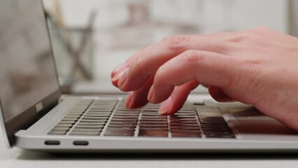 Young woman is typing on computer keyboard close-up. Modern work office place concept. Working and chatting in personal laptop