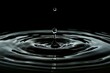 © ylivdesign - Closeup of a water droplet creating ripples on a dark surface. Perfect for peaceful concepts