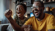 © john - Excited african american father and adult son watching sport on tv and celebrating victory