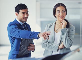 Canvas Print - People, salesman and car dealership with client, pointing and confident in transport, loan or test drive in vehicle. Woman, man and excited in showroom for decision in buying new automobile in shop